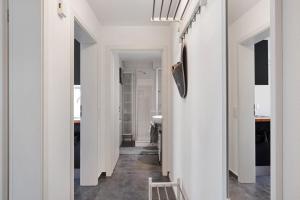 a hallway of a house with white walls and a stool at Bachblick in Buchenbach +19 photos