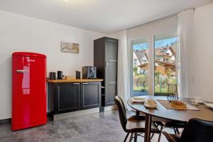 a red refrigerator in a kitchen with a table at Bachblick in Buchenbach
