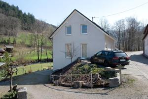 a car parked in front of a white house at Bachblick in Buchenbach