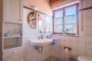 a white bathroom with a sink and a mirror at Haus Desor in Kressbronn am Bodensee +13 photos