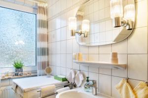 a bathroom with a sink and a mirror at Heidis Fewo in Hohenkirchen +15 photos