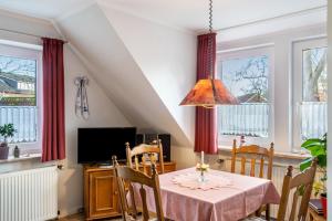 a dining room with a table and chairs and windows at Heidis Fewo in Hohenkirchen