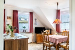 a dining room with a table and a tv at Heidis Fewo in Hohenkirchen