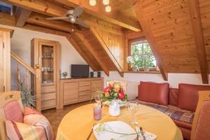 a living room with a table with flowers on it at Haus Desor in Kressbronn am Bodensee