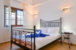 a bedroom with a black bed with white sheets and a window at Villa Gauda in Lanzarote