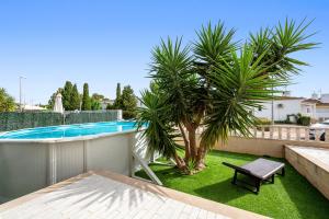 a balcony with a pool and a palm tree at La Terraza in Riumar