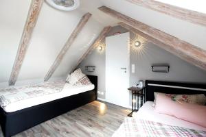 two beds in a room with white walls and wooden floors at Uhses Ferienwohnung in Heide