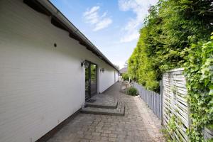 an alley with a white building and a fence at Uhses Ferienwohnung in Heide