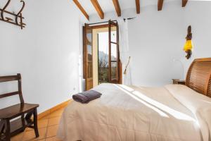 a bedroom with a bed and a chair and a window at Es Tarongers in Sóller +19 photos