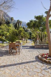 a patio with a table and chairs in a park at Es Tarongers in Sóller