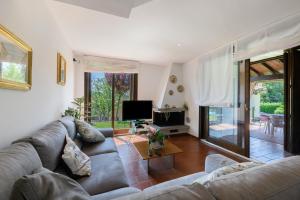 a living room with a couch and a television at Residenza Le Paolette con piscina in Padenghe sul Garda