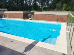 a swimming pool with blue water in front of a building at Maia House da Piscina in Folgosa +3 photos