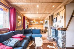a living room with a blue couch and a fireplace at Chalet Farapreu in Manigod