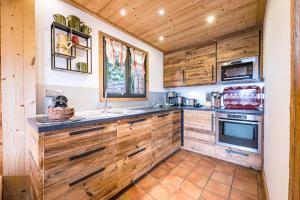a kitchen with wooden cabinets and a sink at Chalet Farapreu in Manigod