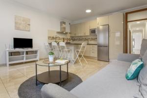 a living room with a couch and a table and a kitchen at Apartamento Rolycar 204 in Icod de los Vinos +16 photos