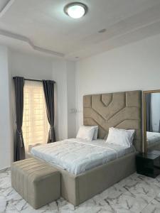a bedroom with a large bed and a mirror at Urban Haven - Orchid, Lekki in Lekki +5 photos