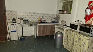 a small kitchen with a sink and a refrigerator at Hostal AMALAYA in Salta