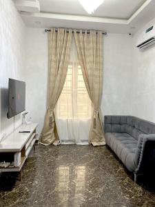 a living room with a couch and a television at Urban Haven - Orchid, Lekki in Lekki