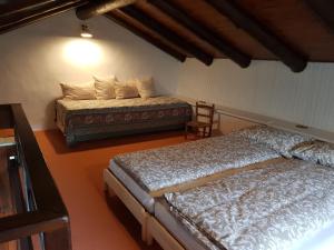 a bedroom with two beds and a chair at Casa Piccola in Falmenta