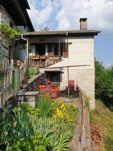 a house with a patio with chairs and an umbrella at Casa Piccola in Falmenta