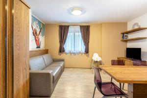 a living room with a couch and a table at Appartamento Tobià in Pozza di Fassa