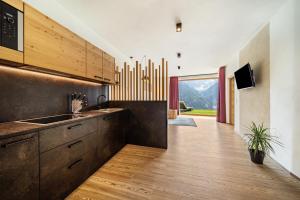 a kitchen with wooden cabinets and a large window at Paflur Lodges Abendrot in Lasa