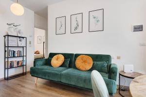 a living room with a green couch with orange pillows at di Pastei 13 in Ledro