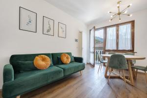 a living room with a green couch and a table at di Pastei 13 in Ledro