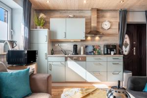 a kitchen with white cabinets and a couch in a room at Ferien mit Hund Blomberg Ostfriesl in Blomberg