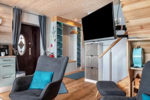 a living room with two chairs and a flat screen tv at Ferien mit Hund Blomberg Ostfriesl in Blomberg
