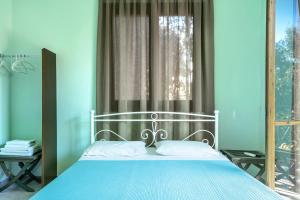 a blue bedroom with a bed and a window at Old Boat double studio 4 in Nikiana