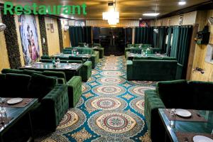 a restaurant with green couches and tables in a room at Tulsi Garden- Near Prem Mandir Vrindavan in Vrindāvan