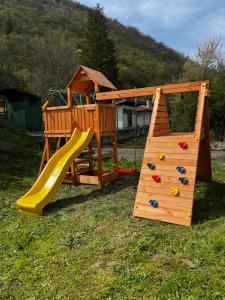 a wooden play set with a slide and a slideintend at Valmont Luxury Chalet in Glozhene