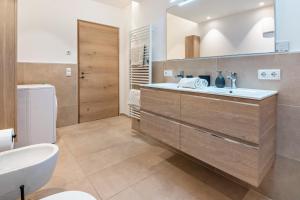 a bathroom with a sink and a toilet at Penthouse - Apartment Venosta in Naturno +19 photos