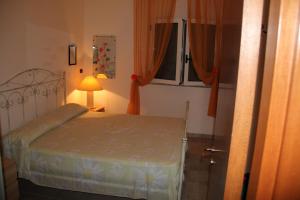 トッレ・ラピッロにあるVilla Rosariaのベッドルーム1室(ベッド1台、ランプ、窓付)