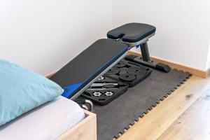a bedroom with a treadmill next to a bed at Penthouse - Apartment Venosta in Naturno