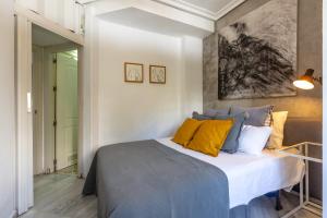 a bedroom with a bed with yellow and blue pillows at Cute apartment oceanfront in Benalmádena