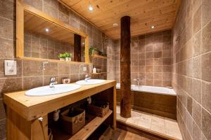 a bathroom with two sinks and a bath tub at Les Chalets de la Revue in Flumet +55 photos