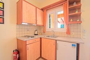 a kitchen with wooden cabinets and a sink at Villa Pepy Studio 3 in Mesongi +14 photos