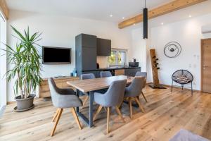 a kitchen and dining room with a wooden table and chairs at Penthouse - Apartment Venosta in Naturno
