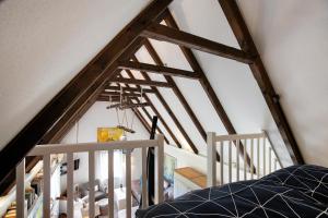 a attic room with wooden rafters and a bed at Hyggelig Am Deich - Ockholm in Ockholm