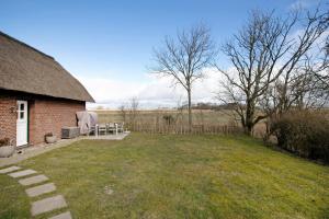 a yard with a brick house with a grass field at Hyggelig Am Deich - Ockholm in Ockholm