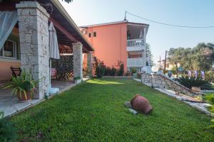 a yard of a house with a large vase in the grass at Villa Pepy Studio 3 in Mesongi