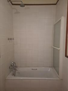 a bathroom with a bath tub with a shower at De Kothuize 10 in Graaff-Reinet