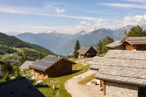 a view of a village with mountains in the background at Hôtel La Perelle in Saint-François-Longchamp