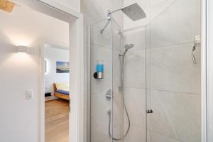 a shower with a glass door in a bathroom at Wolf's Apartment Rheintal in Renchen +22 photos