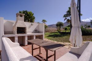 a patio with a table and an outdoor oven at Tramonto A Nordovest in Favignana