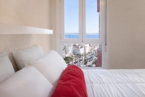 a white bed with a red blanket sitting in front of a window at Seaviews A61 in Torrox Costa