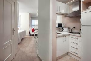 a kitchen with white cabinets and a room with a bed at Seaviews A61 in Torrox Costa