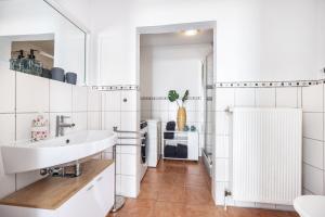 a white bathroom with a sink and a shower at Ferienwohnung Gartencity in Geesthacht +19 photos